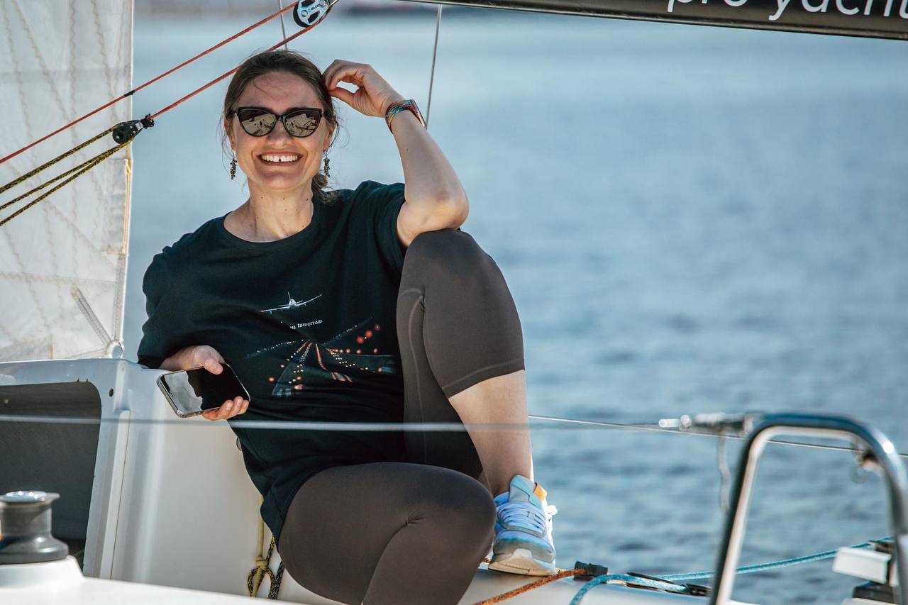 Участница экипажа улыбается на борту J/70